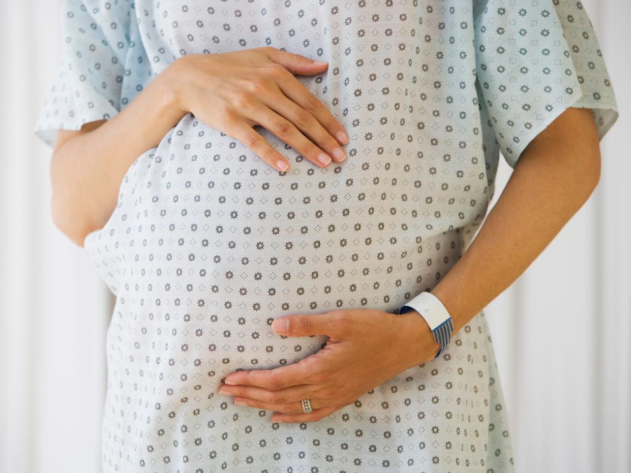 Pregnant person in hospital gown.