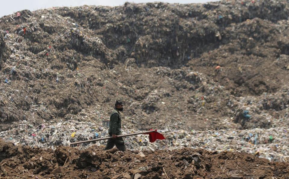 <p>Ein Soldat macht sich auf den Weg, um eine rote Flagge aufzustellen – sie markiert gefährliche Bereiche nach dem Einsturz einer Mülldeponie in Colombo in Sri Lanka. (Bild: Eranga Jayawardena/AP) </p>