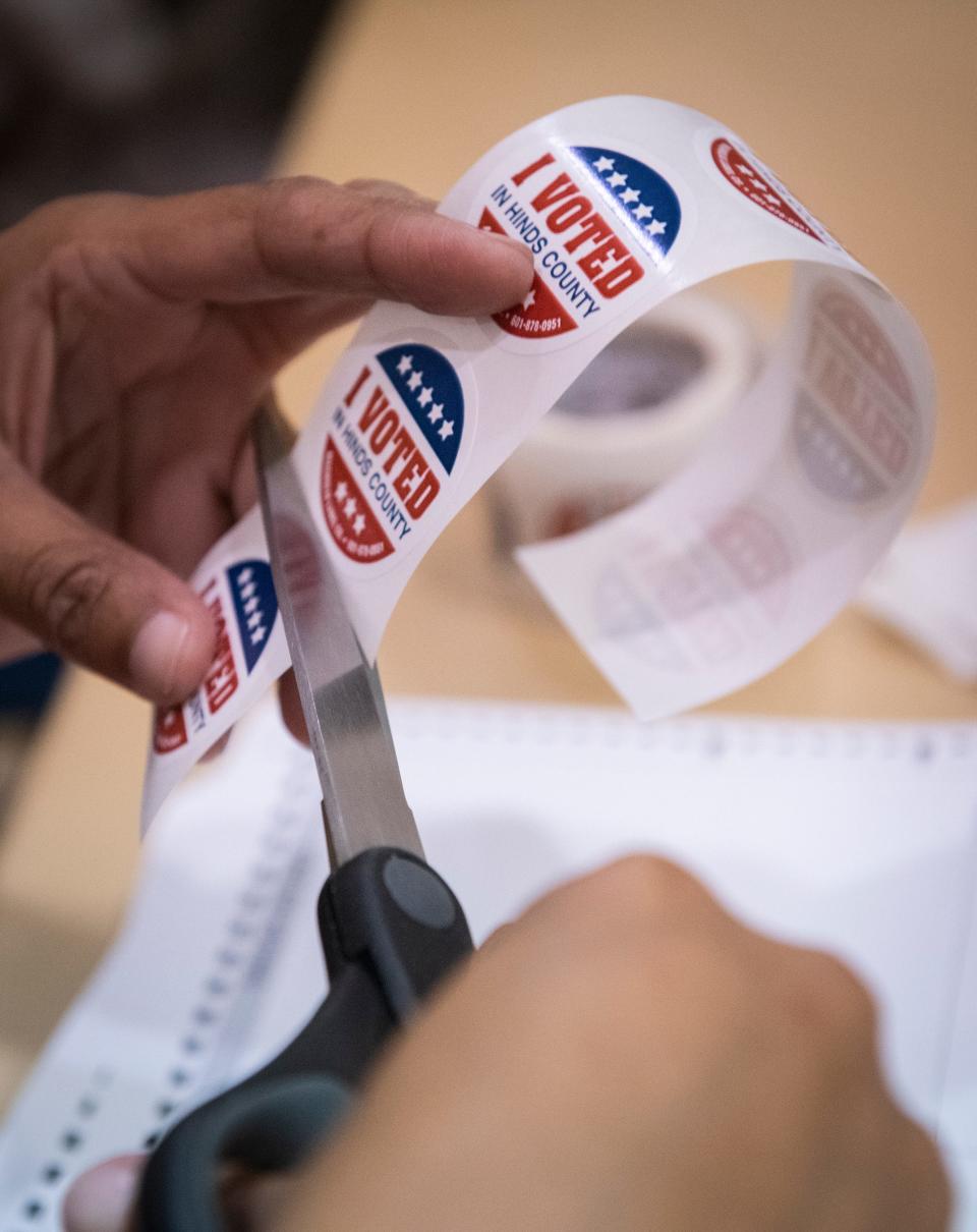 A poll worker prepares "I Voted" stickers to hand out to voters at Precinct 46 in Christ United Methodist Church Tuesday, Nov. 23, 2021. Mississippi is violating the U.S. Constitution's ban on cruel and unusual punishment by permanently stripping voting rights from people convicted of some felonies, a federal appeals court panel ruled in a split decision Friday.