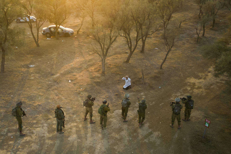 Israeli soldiers surround a Palestinian who ran at them with a knife at the site of a music festival near the border with the Gaza Strip Thursday, Oct. 12, 2023. At least 260 Israeli festival-goers were killed during the attack last Saturday. (AP Photo/Erik Marmor)