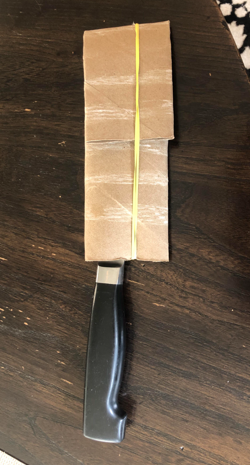 cardboard covering the blade and secured with rubber bands