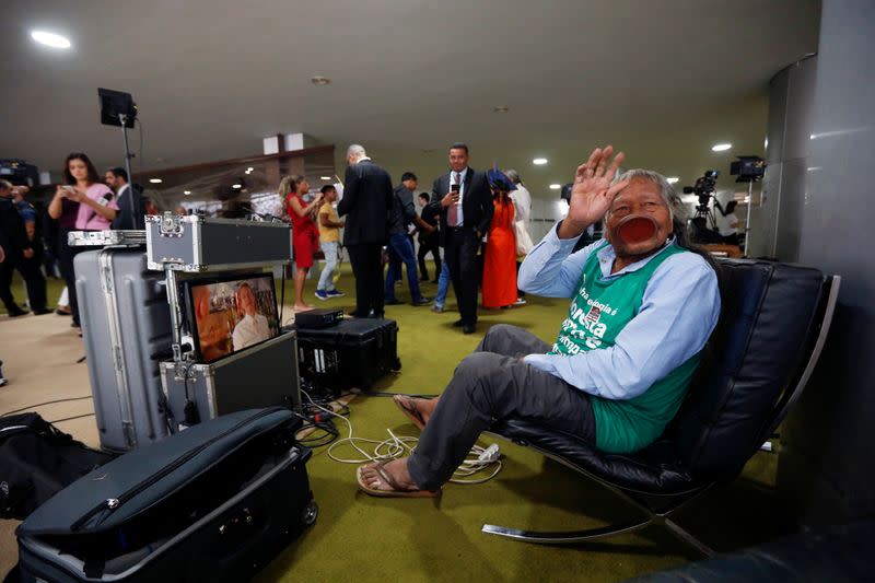 Brazil's indigenous chief Raoni Metuktire waves after a meeting with the parliamentary front in defense of the rights of indigenous people in Brasilia