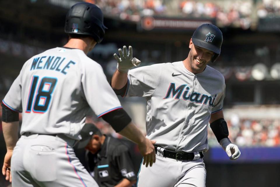 El catcher de los Marlins Jacob Stallings (der.) celebra tras pegar un jonrón en el séptio inning del partido ante los Gigantes, el 8 de abril de 2022 en San Francisco.