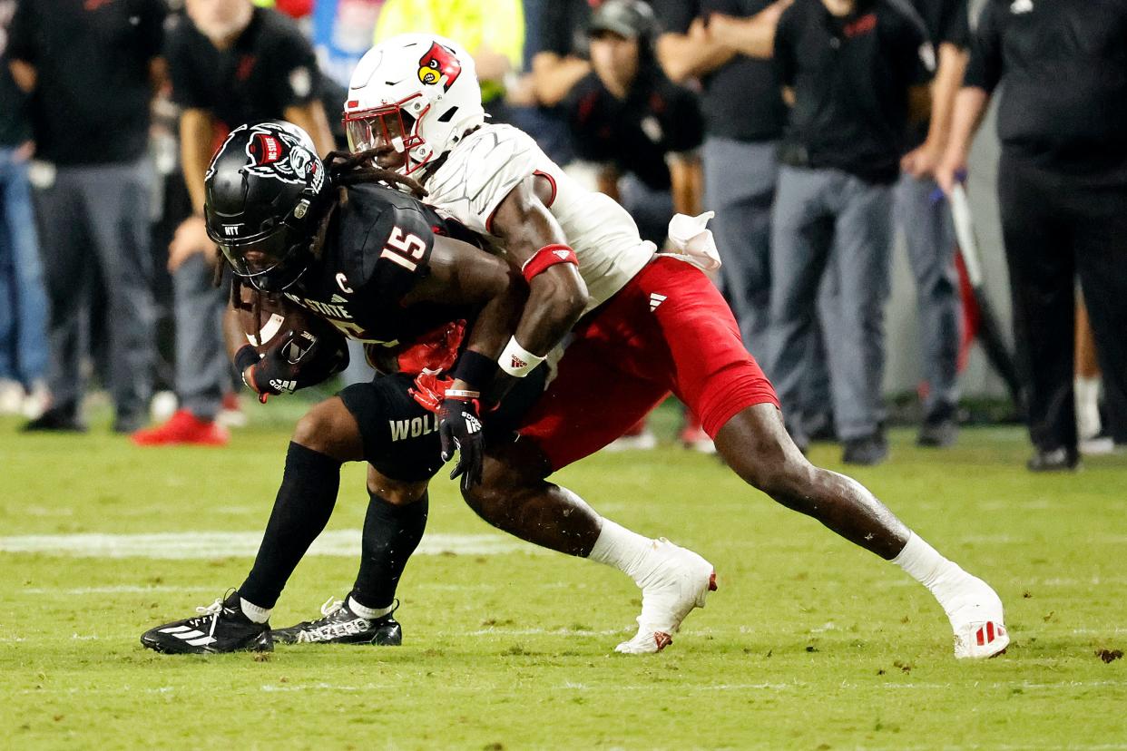 North Carolina State's Keyon Lesane (15) is stopped by of Louisville's Jarvis Brownlee Jr. (2) during the first half of an NCAA college football game in Raleigh, N.C., Friday, Sept. 29, 2023. (AP Photo/Karl B DeBlaker)