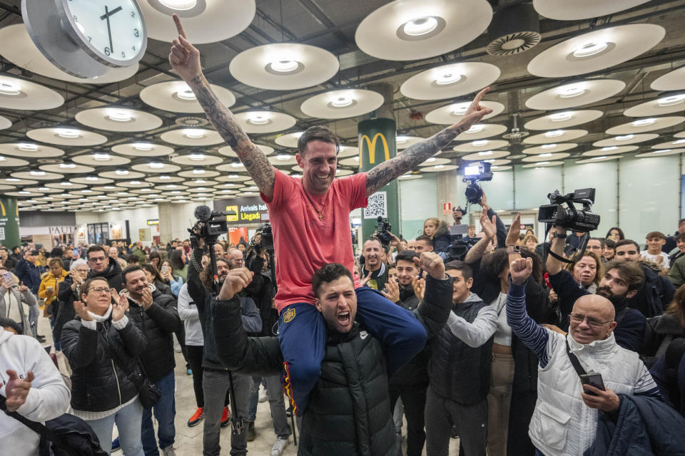 Spanish Santiago Sanchez Cogedor, top, is welcomed by friends and family members at the Barajas airport, outskirts of Madrid, Spain, Tuesday, Jan. 2, 2024. Sanchez Cogedor, who spent 15 months in an Iranian prison after visiting the tomb of Masha Amini, returned home to Madrid on Tuesday after being released. (AP Photo/Bernat Armangue)