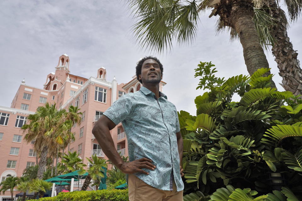 Jared Wofford poses for photos outside of the Don Cesar hotel Thursday, June 17, 2021, in St. Petersburg, Fla. Wofford portrays a bartender at the hotel in the Amazon series "Life's Rewards," an original, scripted TV series commissioned by travel marketers in St. Petersburg and Clearwater, Florida, seeking to draw quarantine-weary tourists to the area's sugar sand beaches. (AP Photo/Chris O'Meara)