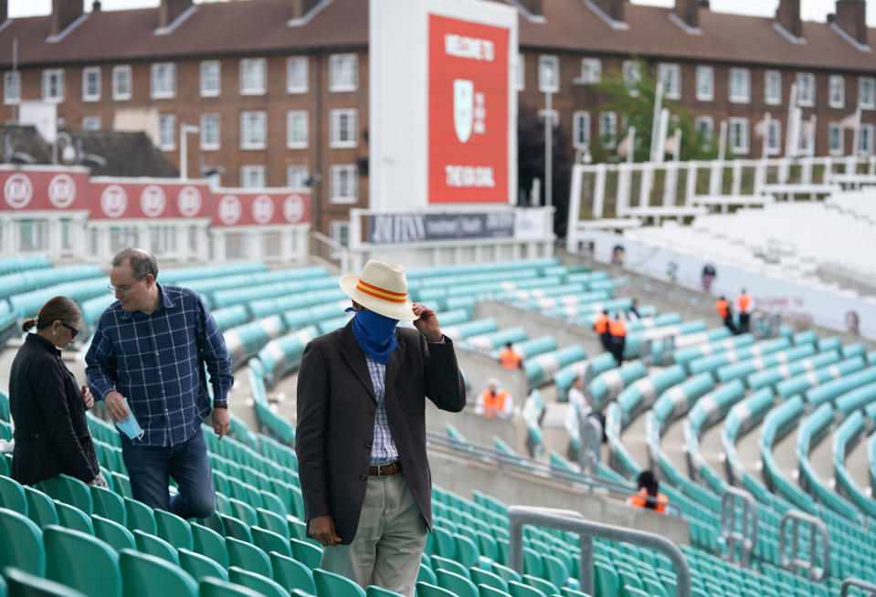 A spectator wearing a face covering takes his seat. (PA)