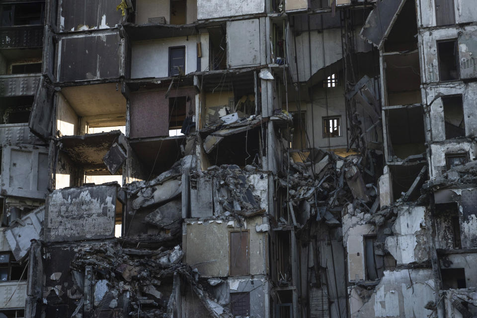 FILE - A view of a building which had been destroyed in a Russian attack in Kharkiv, Ukraine, July 1, 2022. As Russia's invasion of Ukraine grinds into its fifth month, some residents close to the front lines remain in shattered and nearly abandoned neighborhoods. One such place is Kharkiv's neighborhood of Saltivka, once home to about half a million people. Only perhaps dozens live there now, in apartment blocks with no running water and little electricity. (AP Photo/Evgeniy Maloletka, File)