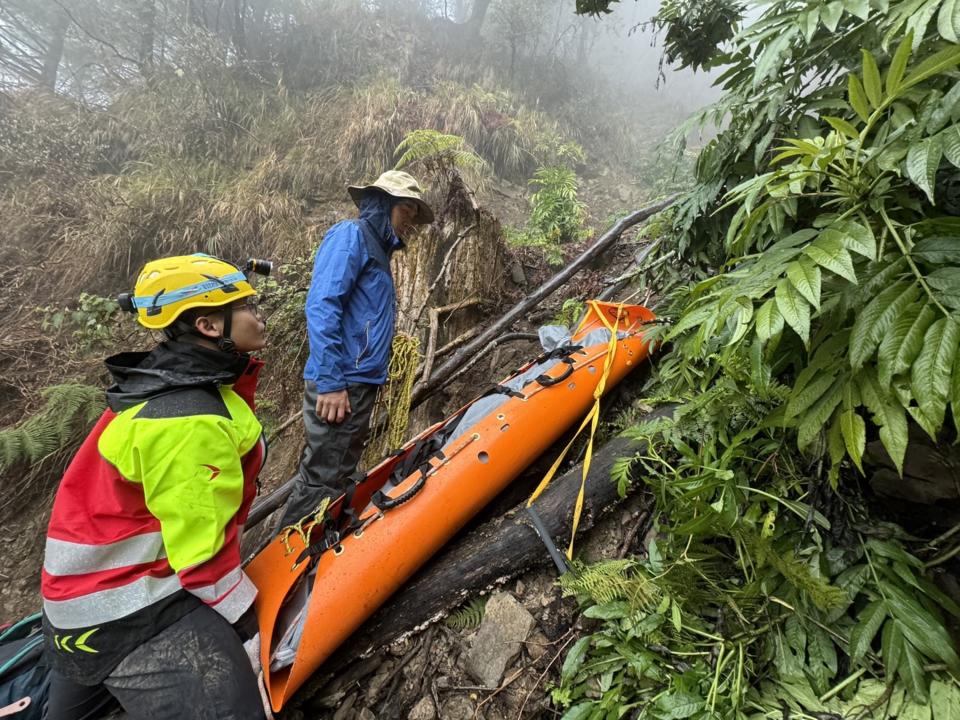 新北三峽登山社一行25人日前到嘉義阿里山鄉塔塔加往白雪村登山露營，其中66歲林姓女子跌落邊坡疑已死亡，警消2日尋獲遺體，並搬運遺體下山。（圖／警方提供）