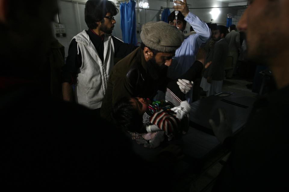 Medics attend to a girl who was injured in a bomb blast at a hospital in Peshawar