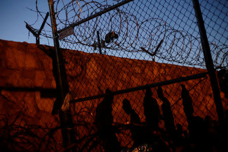 Central American migrants cast their shadows against a wall while inside an enclosure where they are being held by U.S. Customs and Border Protection (CBP), after crossing the border between Mexico and the United States illegally and turning themselves in to request asylum, in El Paso, Texas, March 28, 2019. REUTERS/Jose Luis Gonzalez