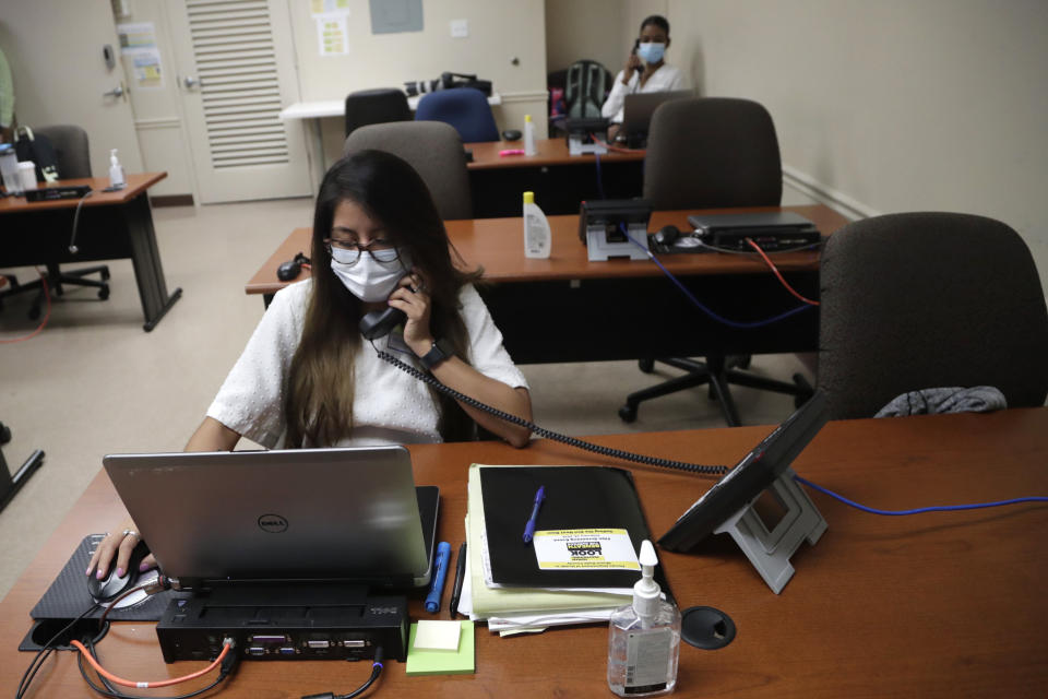 In this Wednesday, May 13, 2020 photo, Maria Fernanda works on contact tracing at the Florida Dept. of Health in Miami-Dade County, during the new coronavirus pandemic, in Doral, Fla. In state after state, the local health departments charged with doing the detective work of running down the contacts of coronavirus patients are falling well short of the number of people needed to do the job. (AP Photo/Lynne Sladky)