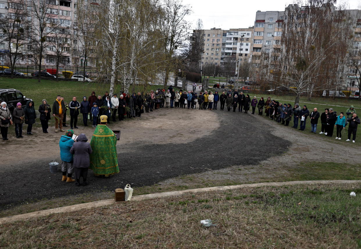 People take part in the consecration of the willow branches outside a church.