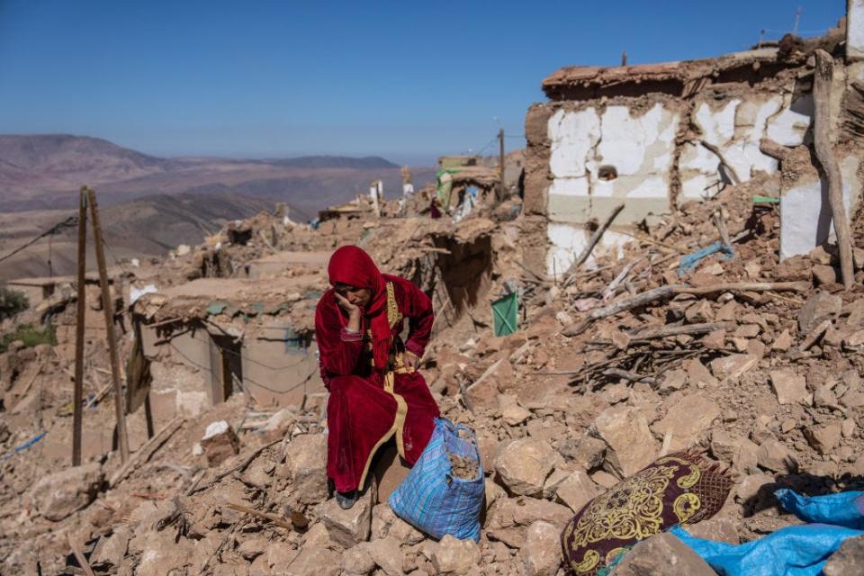 A woman sits amongst the rubble of her village that was almost completely destroyed by an earthquake in Morocco
