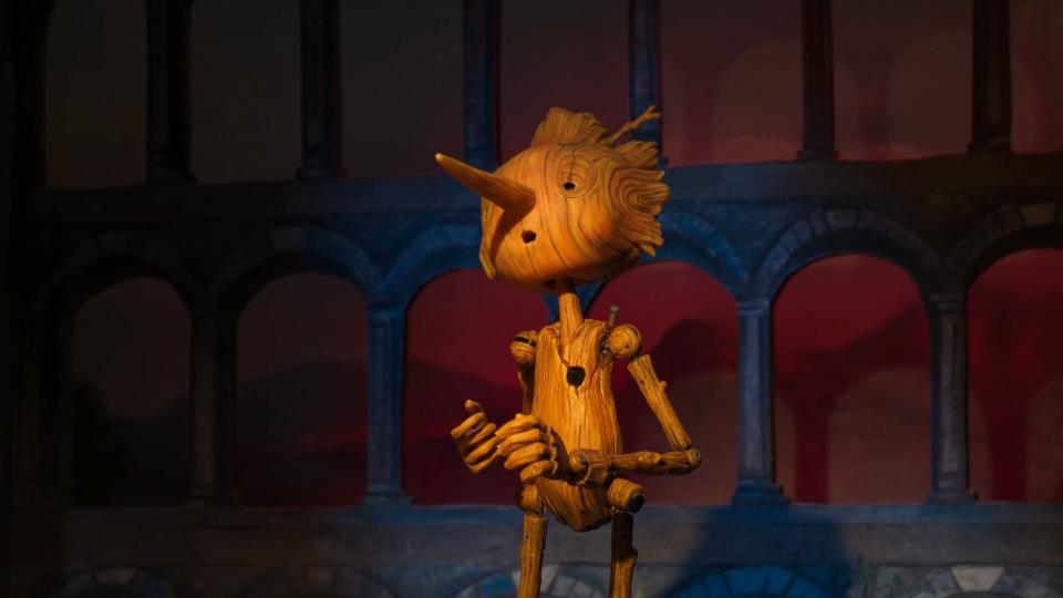 a wooden boy sings on stage