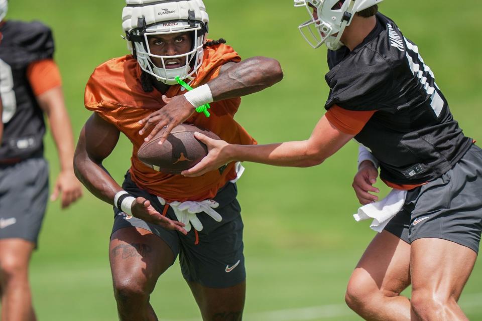 Texas running back CJ Baxter takes a handoff from quarterback Arch Manning during a July 31 practice at Denius Fields. Baxter, who was expected to be the Longhorns' starter, was lost for the season Tuesday with a knee injury.