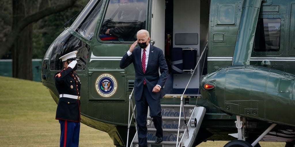 President Joe Biden salutes as he exits Marine One on the South Lawn of the White House