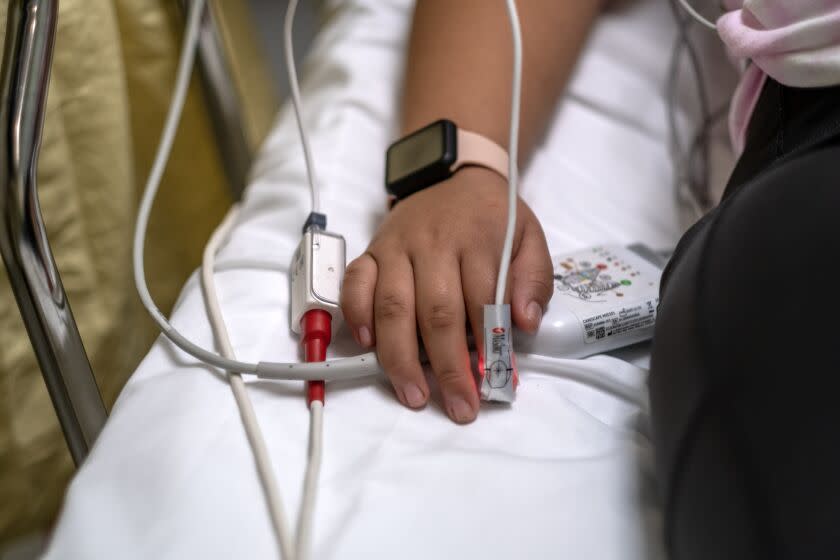 Loma Linda, CA - December 28: Merlina Segeda Rendon, 12, in the emergency department at Loma Linda University Children's Hospital on Wednesday, Dec. 28, 2022, in Loma Linda, CA. Merlina Segeda Rendon has leukemia, had tested positive for the coronavirus on a rapid test at home. The nurse is checking her oxygen levels. She told Merlina it was good - news that the girl relayed to her mother in Spanish - and asked her to sit up and take a deep breath so Perez could listen to her lungs. This was the second time that Merlina had gotten COVID, her mother M. del Carmen said. She worried aloud about how leukemia might complicate efforts to treat her daughter for the virus. (Editors note: NO RESALES) (Francine Orr / Los Angeles Times)