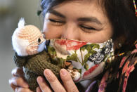 Tobey King, of Corpus Christi, Texas, embraces the crochet Bernie Sanders doll that she made and sold on eBay for $20,300 on Tuesday, Jan. 26, 2021. All of the proceeds are being donated to Meals on Wheels. (Billy Calzada/The San Antonio Express-News via AP)