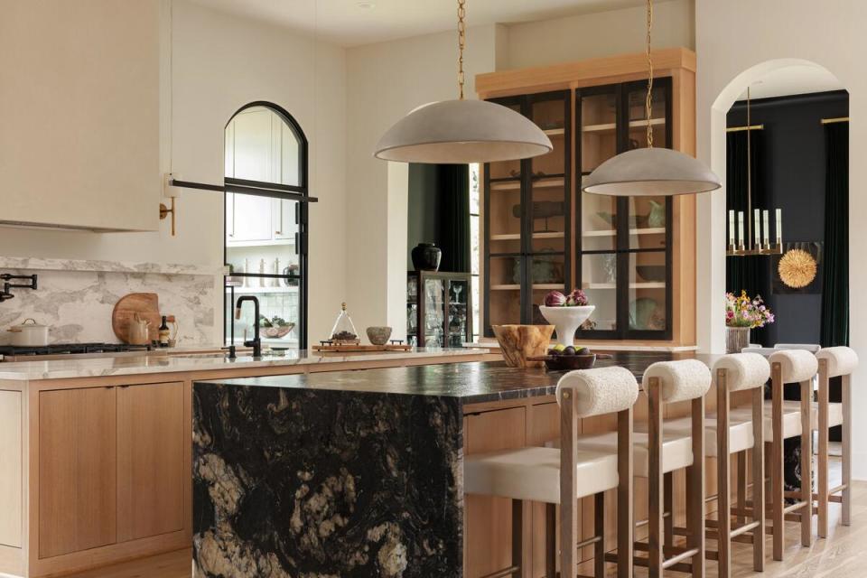 A kitchen in white oak and black steel plays with light and dark on a pair of islands that feature countertops in contrasting hues 