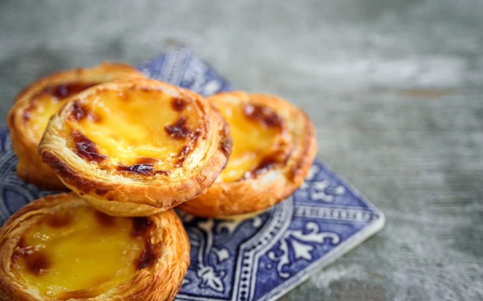 Pasteis de Nata are little custard tarts with a delicate dusting of cinnamon - iStock
