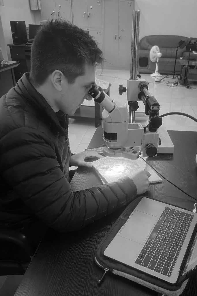 亞歷克斯·克拉克，芝加哥大學和菲爾德博物館的博士研究生，正在檢查他幫助描述的化石——“艾登堡的奇異鳥。（圖／Courtesy of Alex Clark）