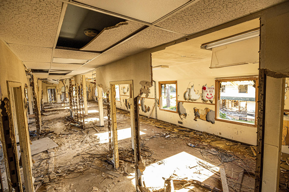 The remains of a hallway stretches down the center of barracks at Fort Ord on Thursday, April 29, 2021, in Fort Ord, Calif. Many veterans of Fort Ord who believe their cancers were caused by exposure to chemicals at the base have been denied disability and medical benefits from the Department of Veterans Affairs. (AP Photo/Noah Berger)