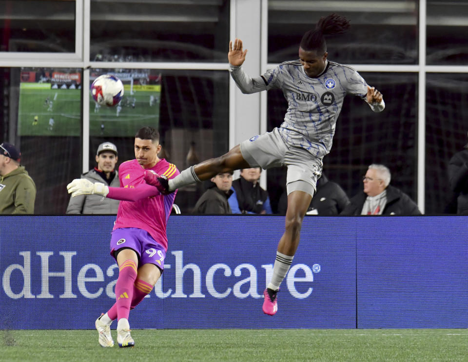 CF Montreal forward Chinonso Offor, right, attempts to block a kick by New England Revolution goalkeeper Djordje Petrović (99) in the first half of an MLS soccer match Saturday, April 8, 2023, in Foxborough, Mass. (AP Photo/Mark Stockwell)