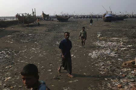 Internally displaced Rohingya men work along the river banks where their fishing boats are docked, in Thae Chaung IDP camp on the outskirts of Sittwe, February 15, 2015. REUTERS/Minzayar