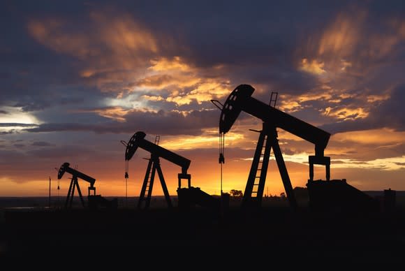 Three oil pumps at sunset.