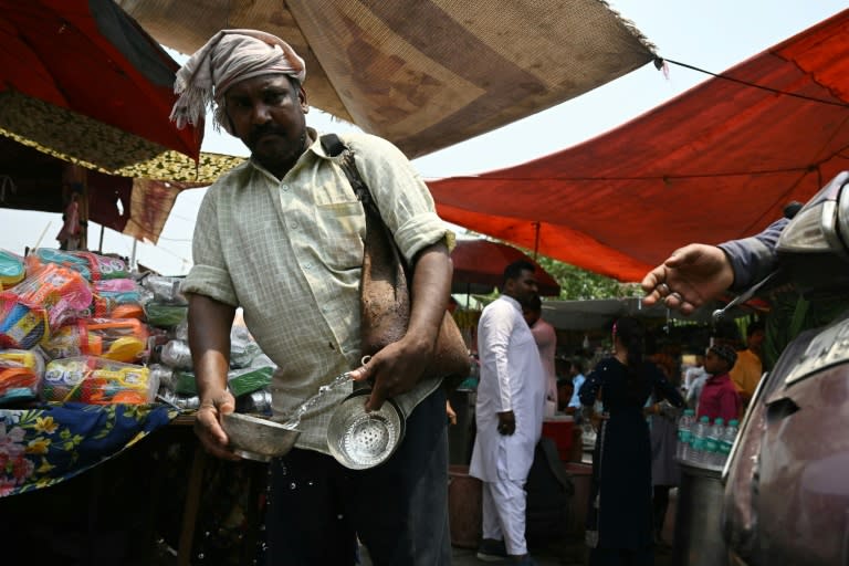 A volunteer distributes water during a hot summer day in Delhi on May 17 (Arun SANKAR)