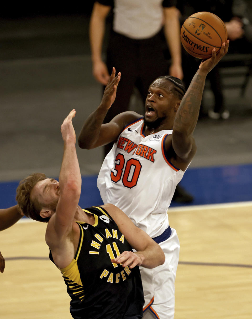 New York Knicks' Julius Randle (30) is called for an offensive foul as he collides with Indiana Pacers' Domantas Sabonis (11) in the fourth quarter of an NBA basketball game Saturday, Feb. 27, 2021, in New York. (Elsa/Pool Photo via AP)