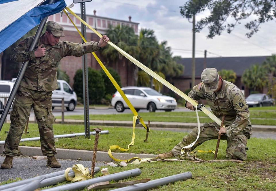 Members of the Florida National Guard help provide residents with food and water at a distribution site in Brownsville on Saturday. Just under 50% of residents in Escambia are still without power following Hurricane Sally's landfall on Wednesday.