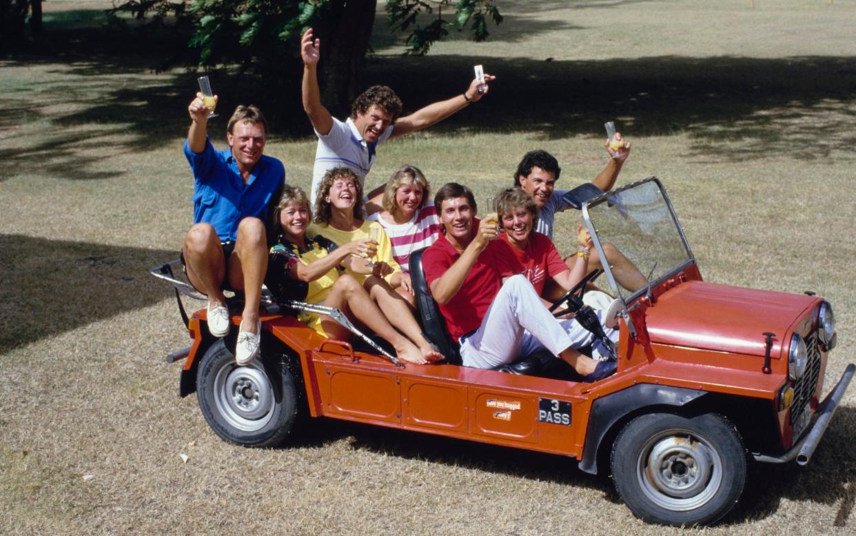 England players and their wives and girlfriends ride a Mini Moke during the 1986 England tour of the Caribbean