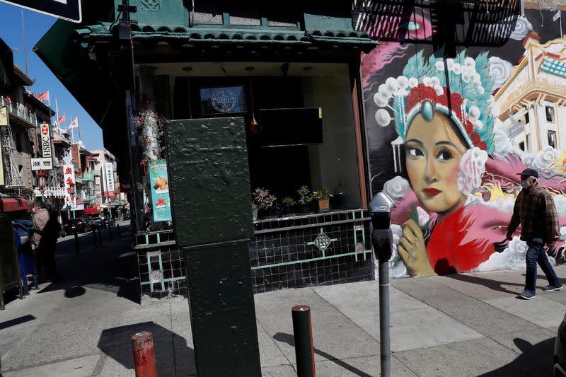 FILE PHOTO: A man wearing a face mask walks through Chinatown Chinatown in San Francisco