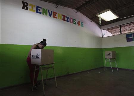 A woman prepares to cast her ballot in the presidential elections, at a polling station outside in San Salvador February 2, 2014. REUTERS/Henry Romero
