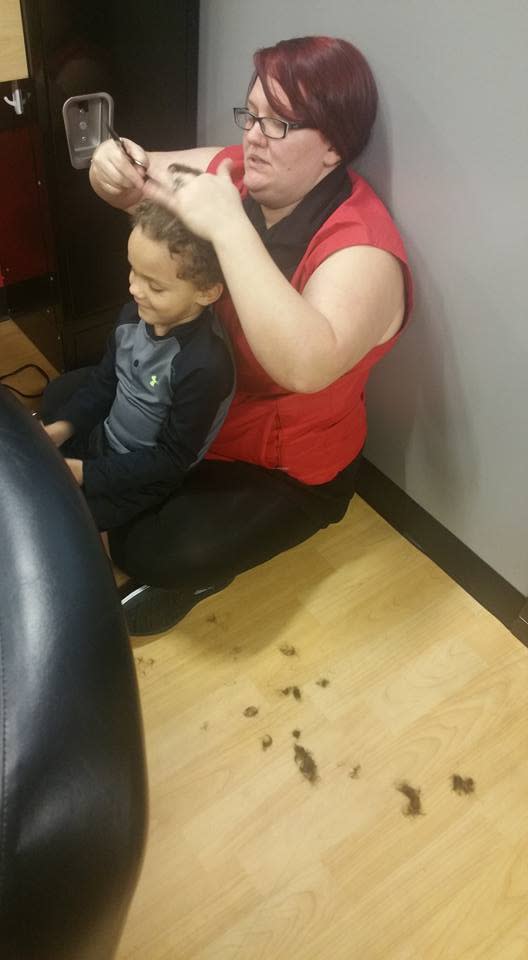 Hairstylist cutting autistic boy's hair