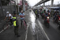 Police inspect motorists at a checkpoint during a stricter lockdown as a precaution against the spread of the coronavirus on the outskirts of Marikina City, Philippines on Friday, August 6, 2021. Thousands of people jammed coronavirus vaccination centers in the Philippine capital, defying social distancing restrictions, after false news spread that unvaccinated residents would be deprived of cash aid or barred from leaving home during a two-week lockdown that started Friday. (AP Photo/Basilio Sepe)