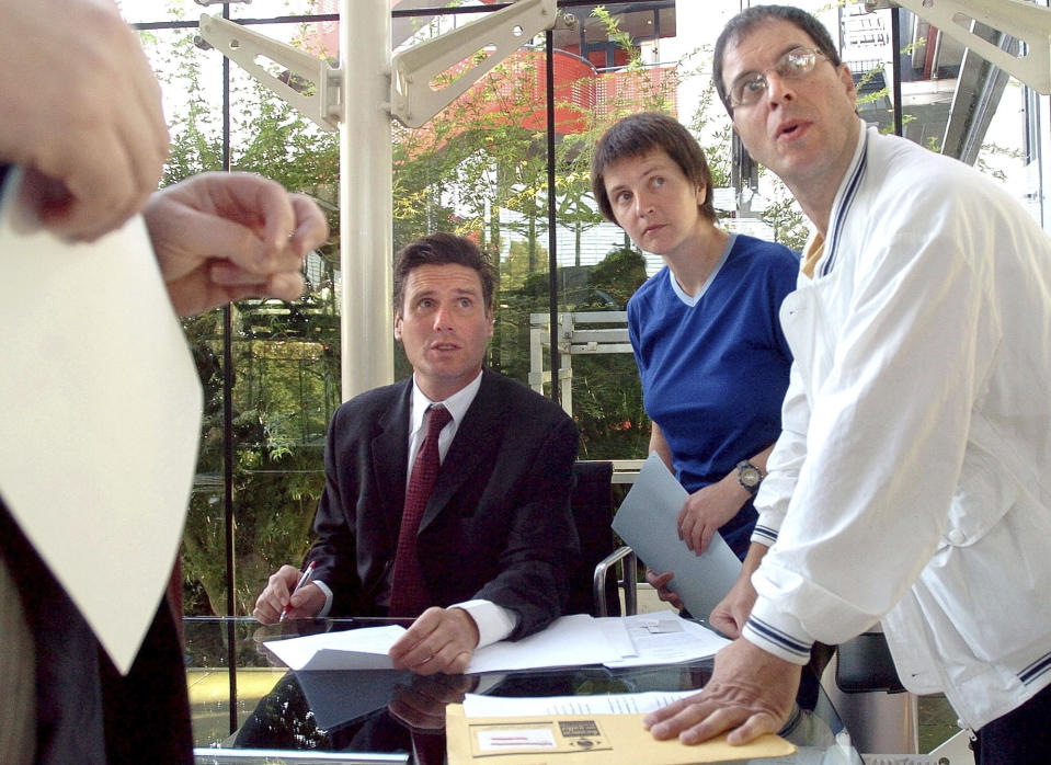 FILE - British environmental activists Helen Steel, second right, and David Morris, right, discuss with their lawyer Keir Starmer, seated, as they wait for the beginning of their hearing at the European Court for Human Rights Tuesday Sept. 7, 2004, in Strasbourg, eastern France. (AP Photo/Christian Lutz, File)