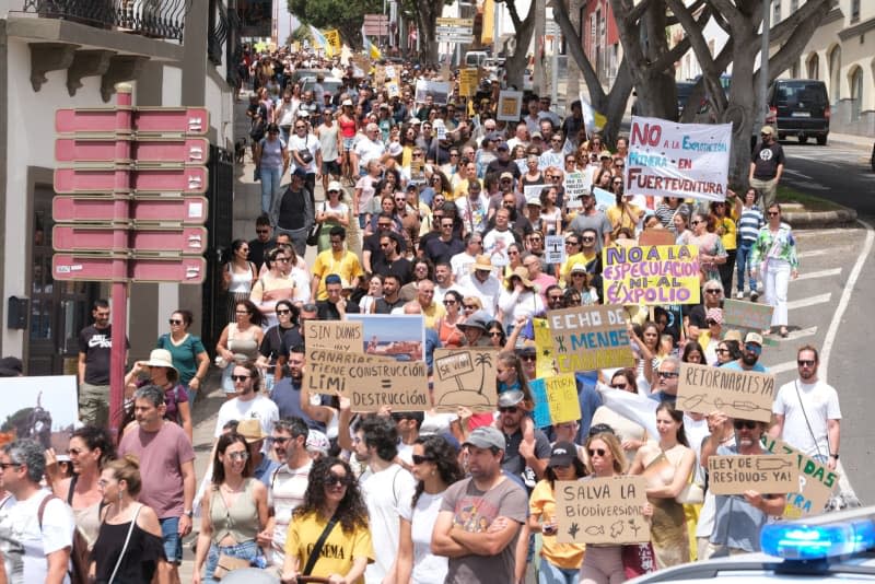 People hold banners and flags during a demonstration against the tourism model under the slogan 'Canarias has a limit'. Europa Press Canarias/EUROPA PRESS/dpa