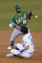 Los Angeles Dodgers' Cody Bellinger doubles to second base ahead of a throw to Oakland Athletics shortstop Marcus Semien during the first inning of their baseball game Tuesday, Sept. 22, 2020, in Los Angeles. (AP Photo/Ashley Landis)