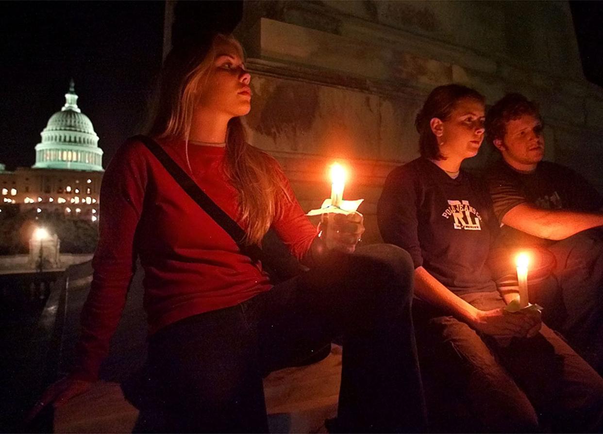 Erin Jones, Bridget Opfer, and Kieran McCutcheon join thousands of people taking part in a candlelight vigil on the Mall in Washington D.C. September 12, 2001 in memory of the victims of the terrorist attacks in New York City and Washington D.C. yesterday. The United States vowed on Wednesday to strike back with a hammer of vengeance for the horrific attacks on the World Trade Center and the Pentagon, described across an angry nation as "an act of war" committed by an enemy whose name it doesn't even know.