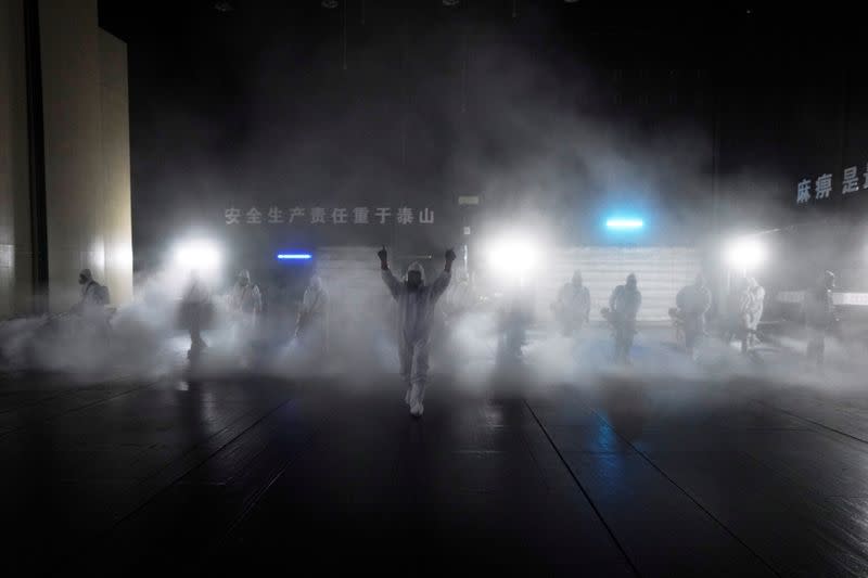 Volunteers from the Blue Sky Rescue team disinfect at the Qintai Grand Theatre in Wuhan