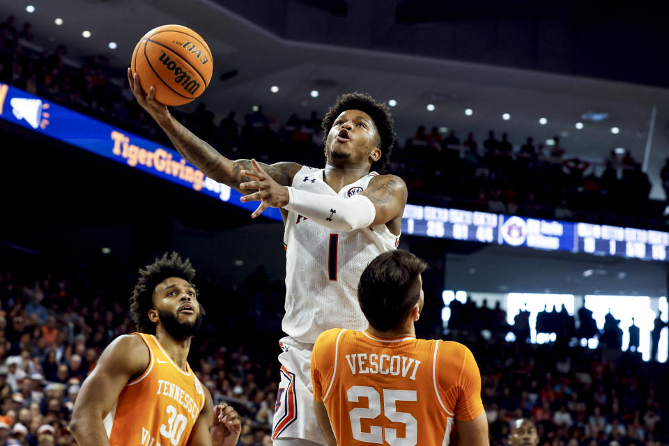 Auburn guard Wendell Green Jr. (1) is fouled by Tennessee guard Santiago Vescovi (25) and he goes up for the basket during the first half of an NCAA college basketball game Saturday, March 4, 2023, in Auburn, Ala. (AP Photo/Butch Dill)