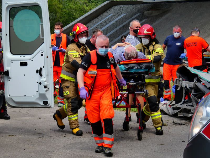 First responders attend to the scene of a public bus crash in Warsaw