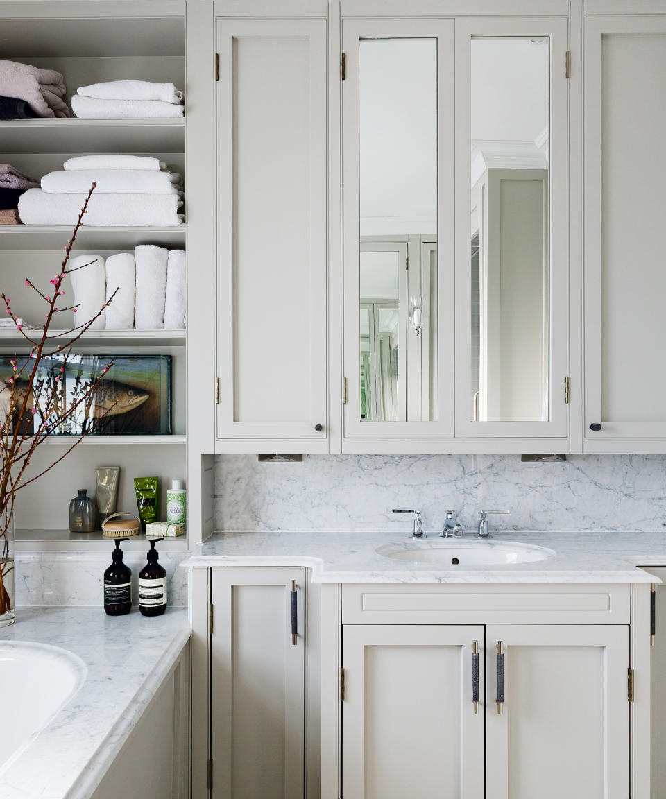 bathroom with bath and sink with vanity and towels on shelves