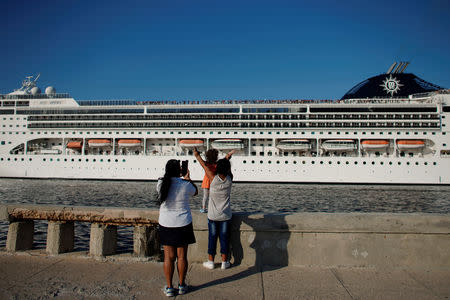 People watch the cruise ship MSC Opera leaving Havana bay in Havana, Cuba, March 13, 2019. Picture taken March 13, 2019. REUTERS/Alexandre Meneghini