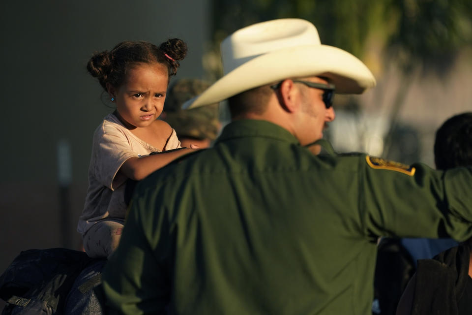 A young girl watches as she and other migrants who crossed the Rio Grande and entered the U.S. from Mexico are lined up for processing by U.S. Customs and Border Protection, Saturday, Sept. 23, 2023, in Eagle Pass, Texas. (AP Photo/Eric Gay)