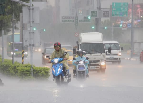 圖：高雄市、台南市大雷雨訊息，高雄市區民眾上班遇到瞬間豪大雨。（記者黃富貴攝）