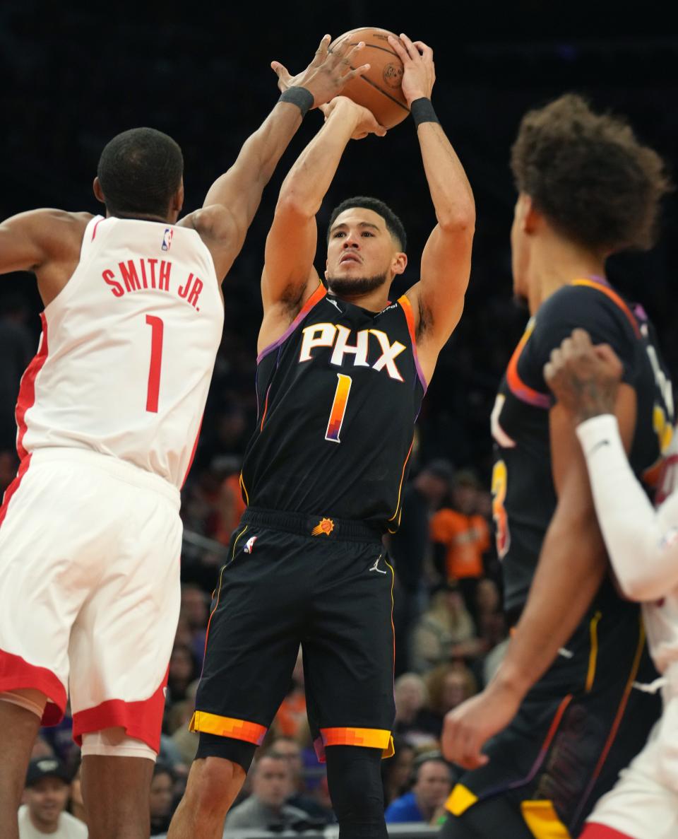 Oct 30, 2022; Phoenix, AZ, USA; Phoenix Suns guard Devin Booker (1) shoots the ball over Houston Rockets guard Jabari Smith Jr. (1) at Footprint Center.